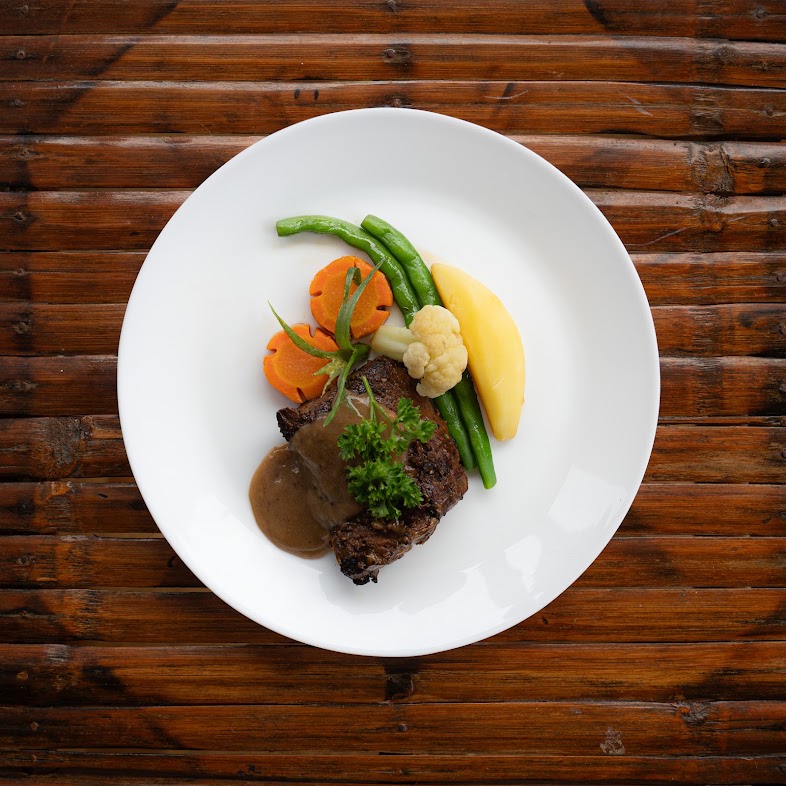 Beef tenderloin with sauce and seasonal vegetables at The Lounge